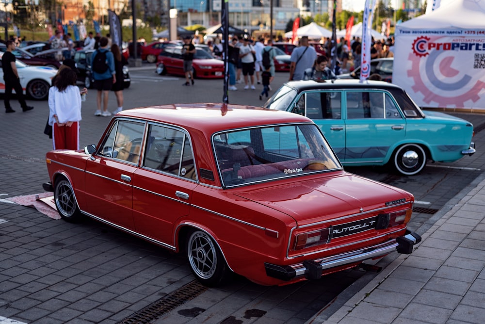 a red car parked next to a blue car on a street