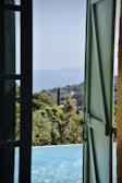 an open door leading to a pool with a view of the ocean