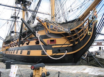 a large yellow and black boat in a harbor