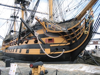 a large yellow and black boat in a harbor