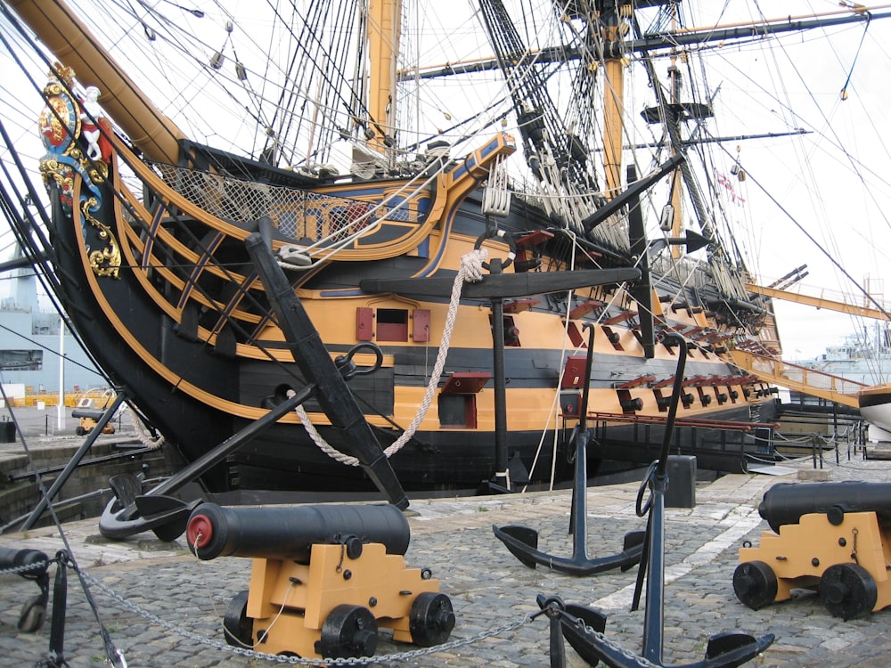 a large yellow and black boat docked at a dock