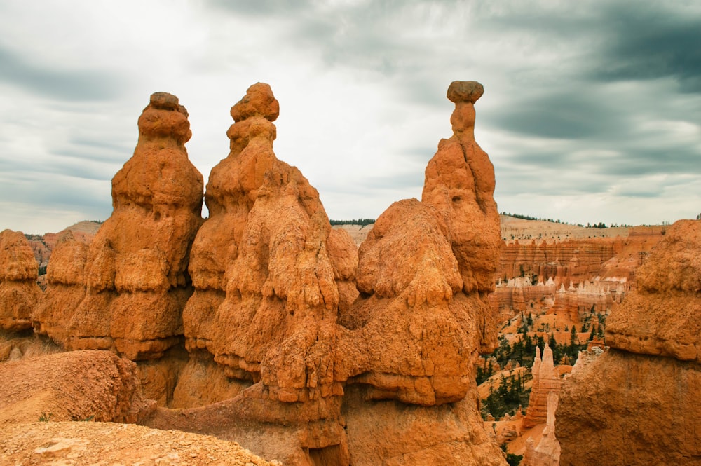 um grupo de formações rochosas no deserto sob um céu nublado