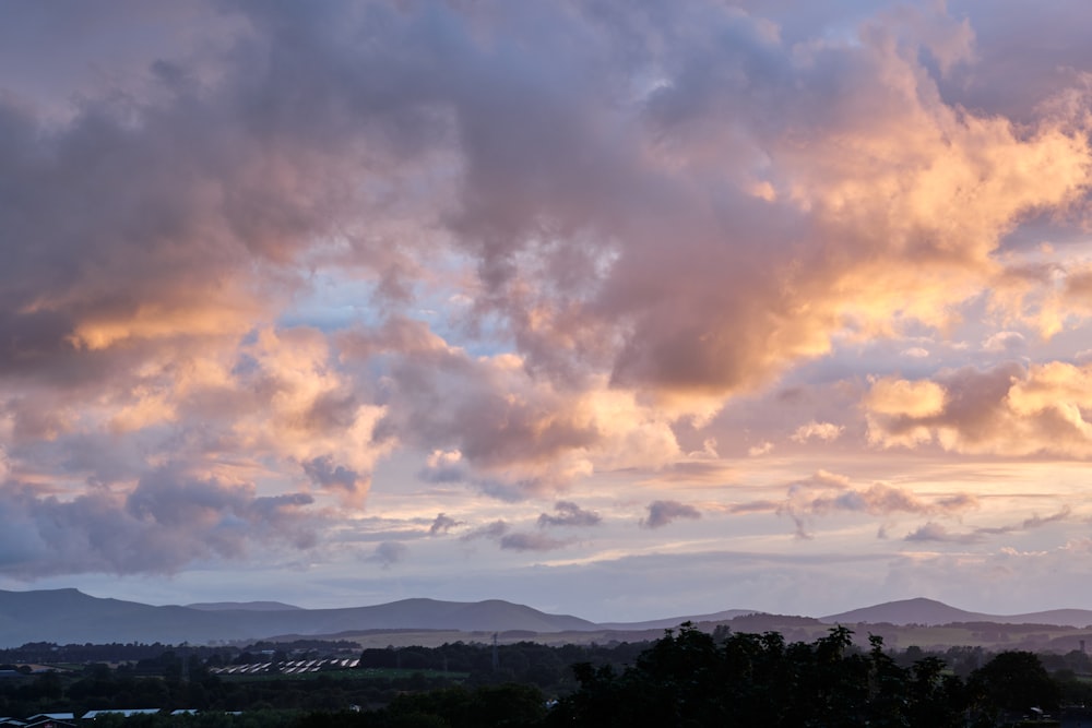 Blick auf einen bewölkten Himmel mit Bergen im Hintergrund