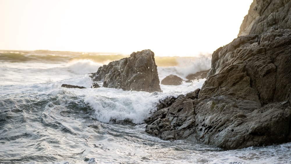 a rock formation with waves crashing against it