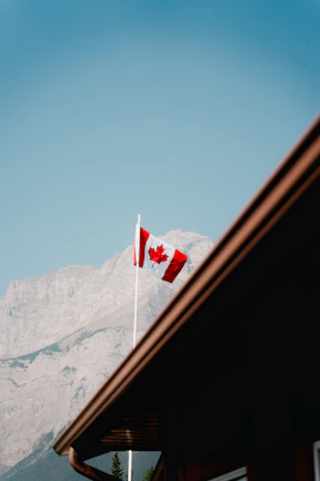 A skilled worker receiving a work permit approval with a Canadian flag in the background.