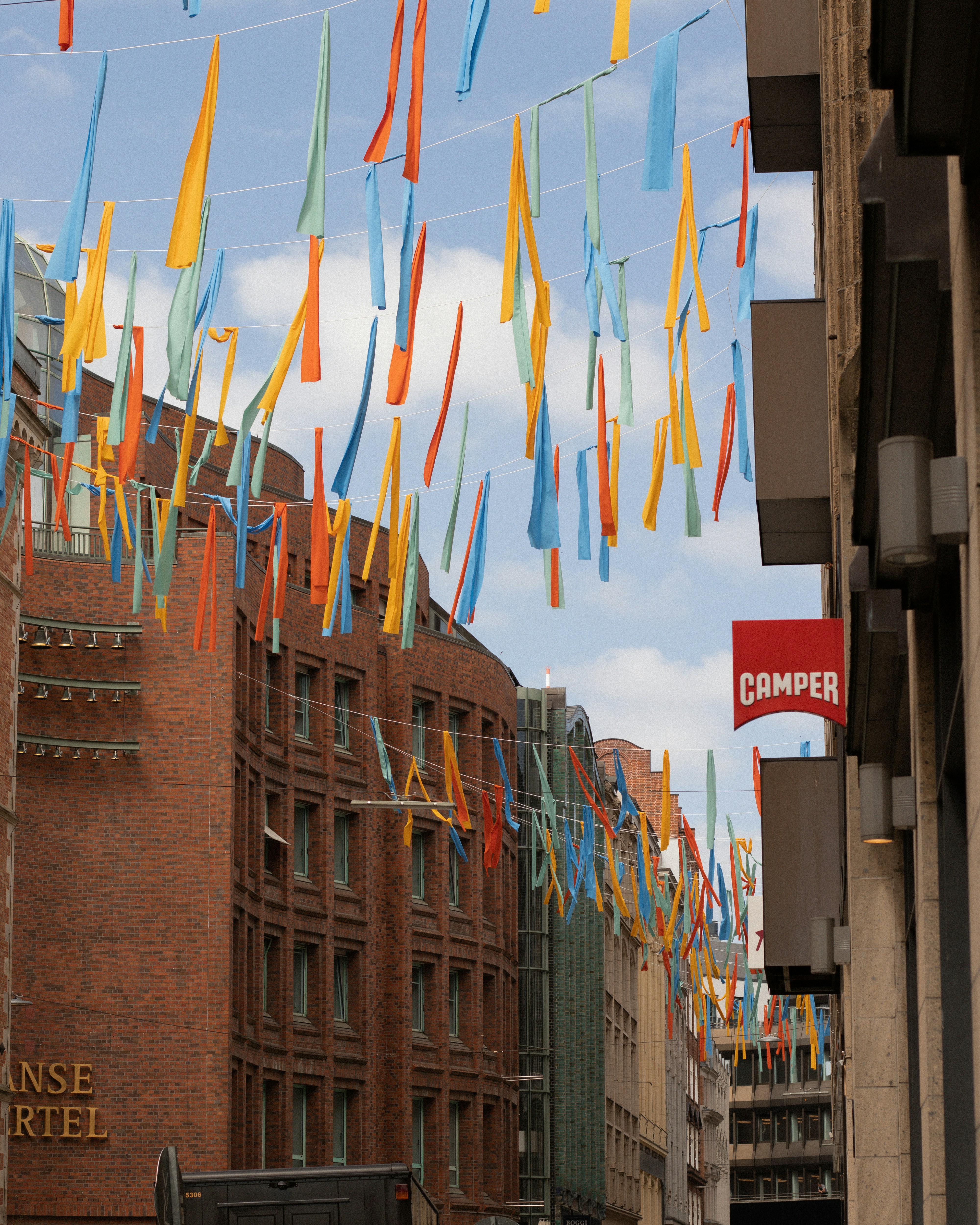 colorful streamers hanging from a building in a city