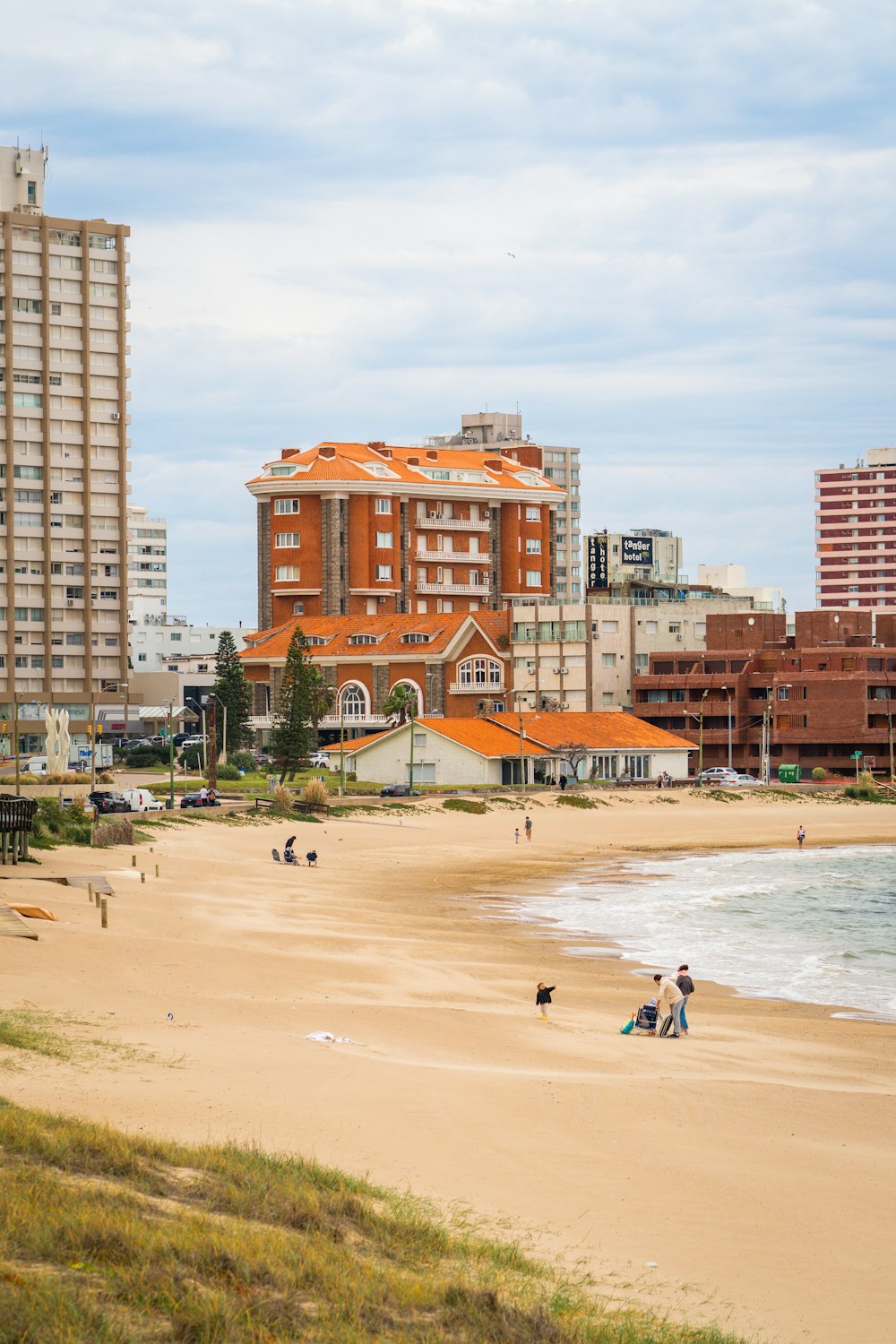 a group of people walking along a sandy beach