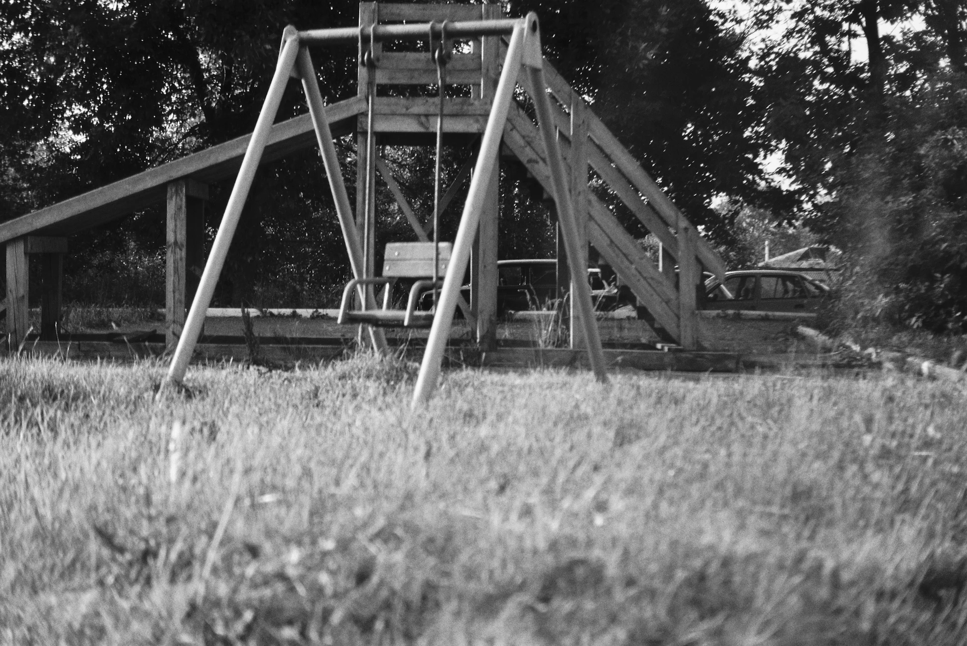 A black-and-white historical photograph showing children playing outside the original school building from decades ago.