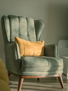 a green chair with a yellow pillow on top of it