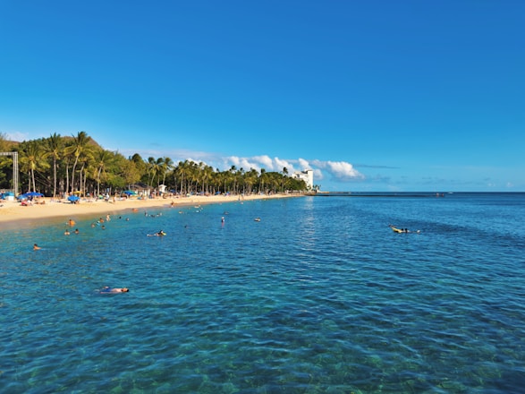 Vibrant tropical beach resort under bright blue sky with happy travelers.