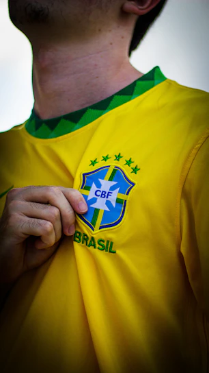 a man wearing a yellow shirt with a brazil emblem on it