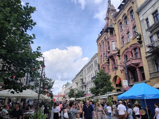 A bustling street scene in Prishtina with people walking and cafes lining the sidewalks.