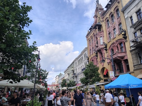 A bustling street scene in Prishtina with people walking and cafes lining the sidewalks.