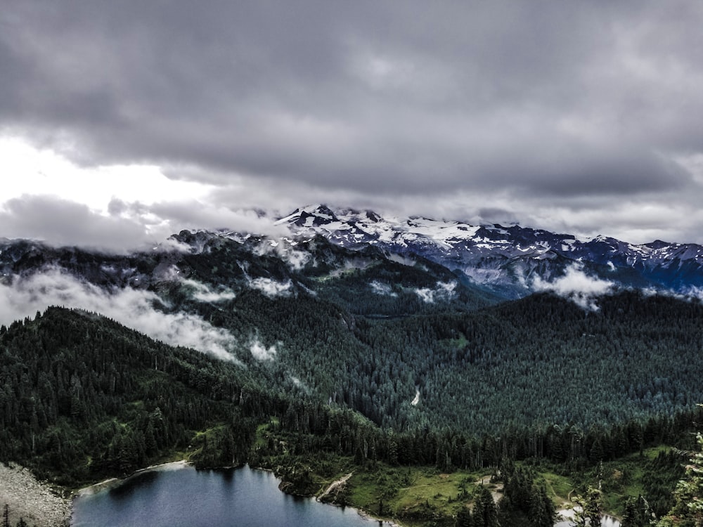 um lago cercado por montanhas sob um céu nublado