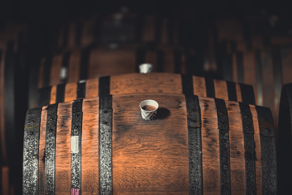 a cup of coffee sitting on top of a wooden barrel