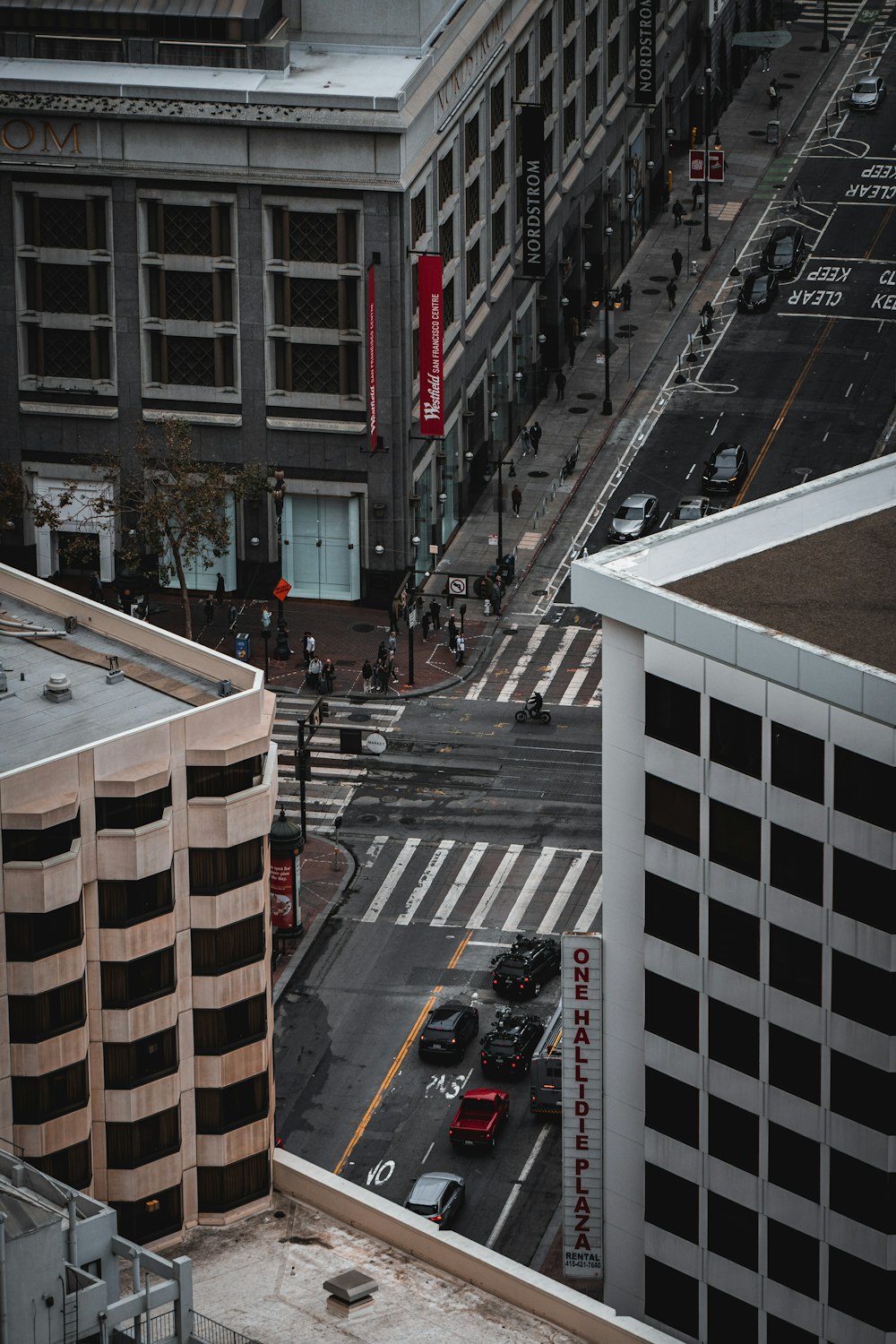 a city street filled with lots of traffic next to tall buildings