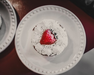 A delicate strawberry shortcake topped with fresh strawberries and a dusting of powdered sugar.
