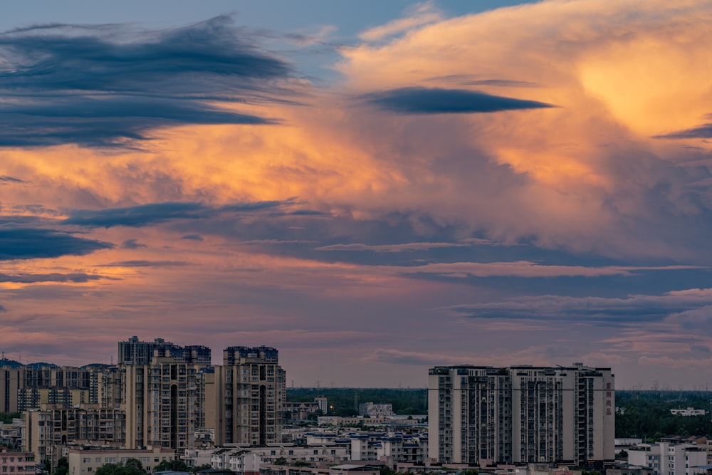 a cloudy sky over a city with tall buildings