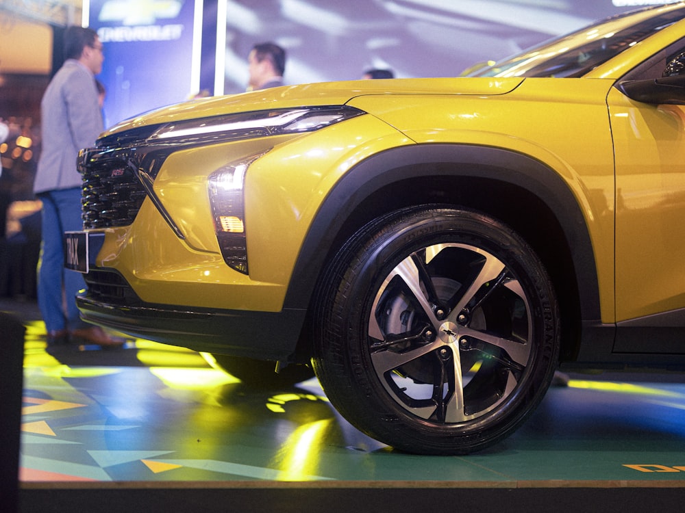 a yellow suv is on display at a car show