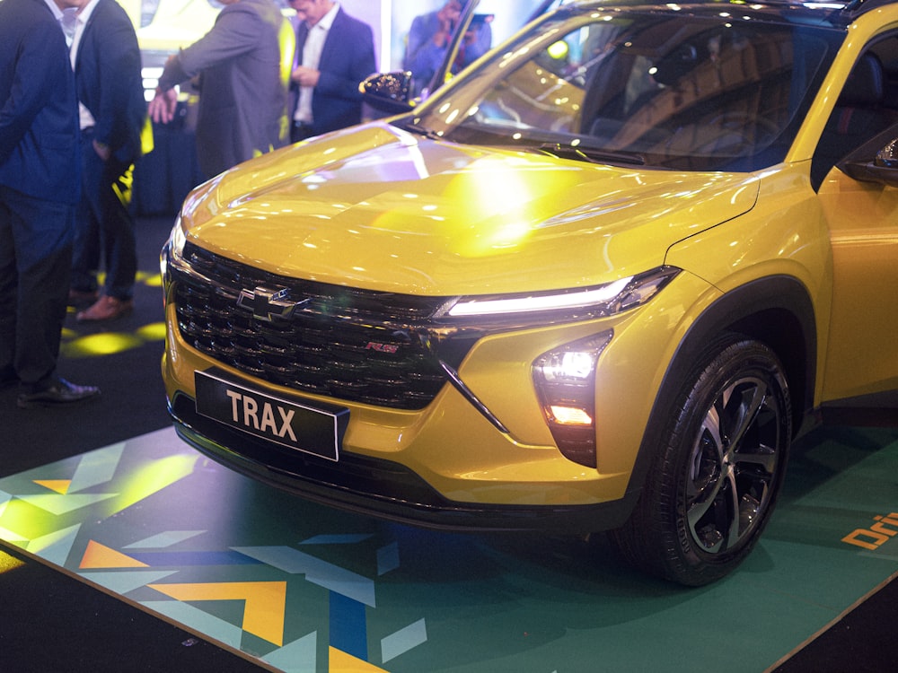 a yellow suv is on display at a car show