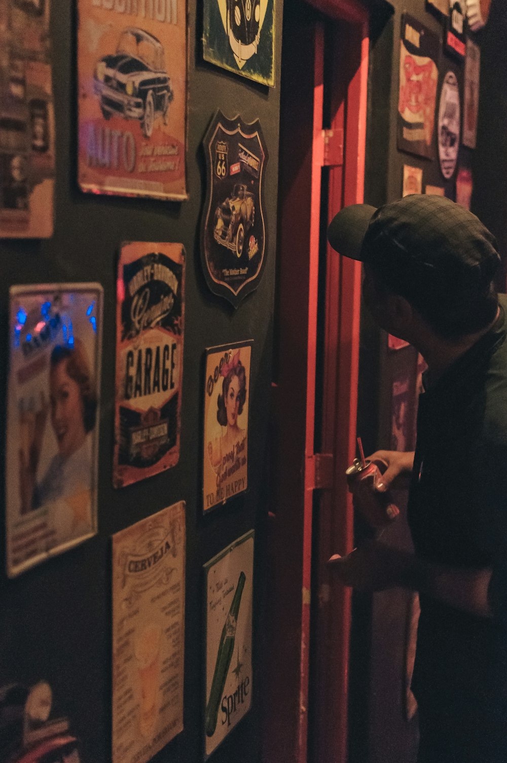 a man standing in front of a wall covered in posters