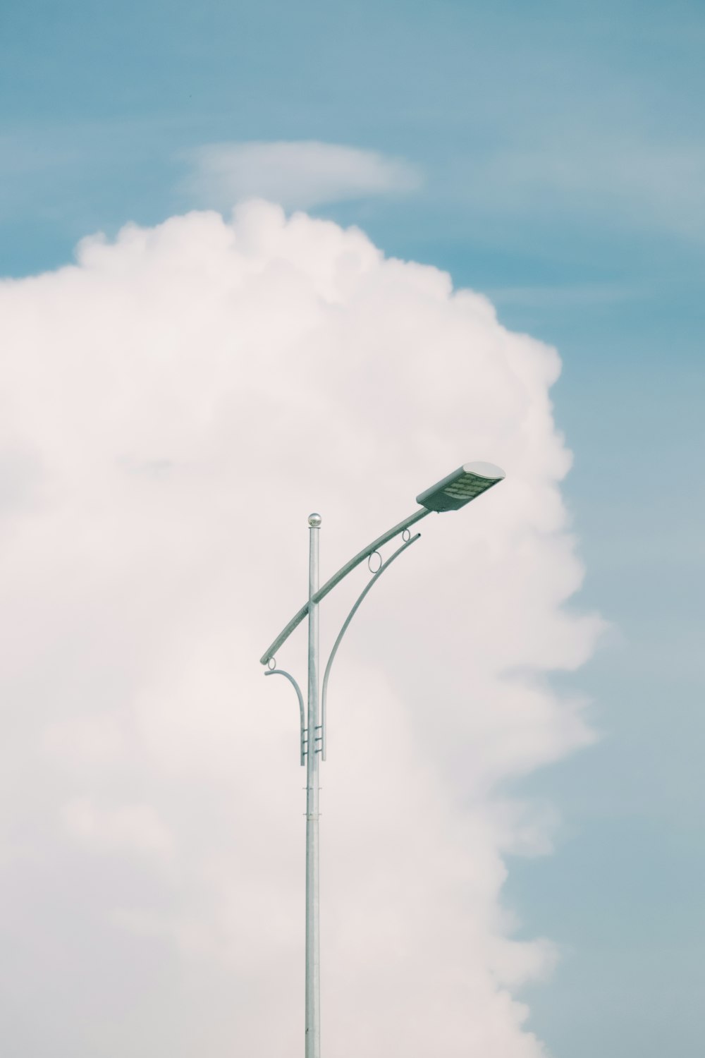 a street light with a cloud in the background