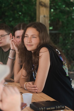 A diverse group of young people engaged in a supportive conversation outdoors.