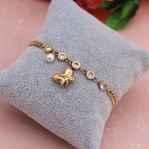 A stylish bracelet with soft rose gold tones showcased against a light cream background.