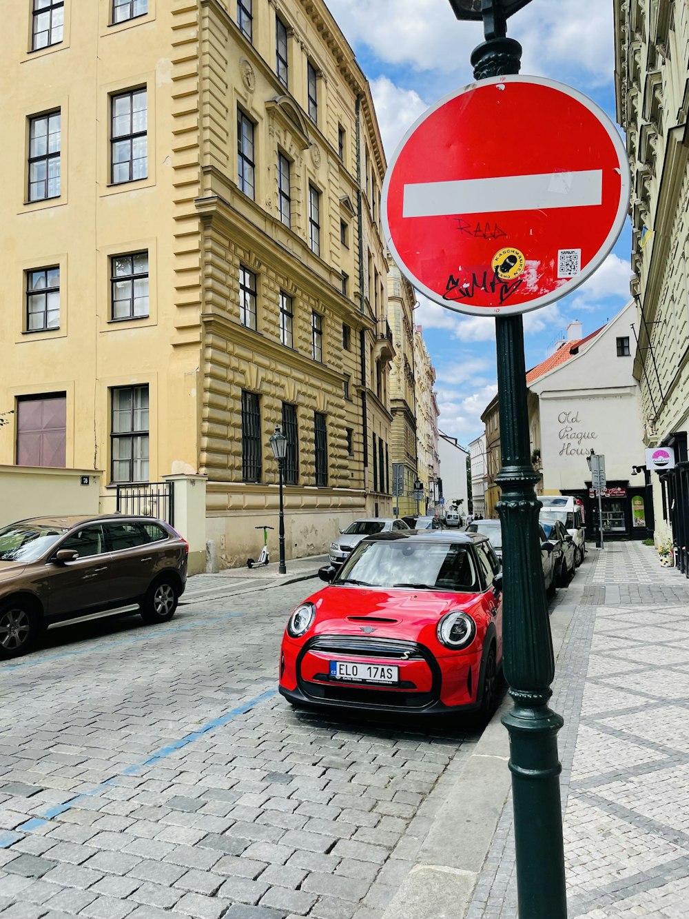 a red car parked next to a street sign