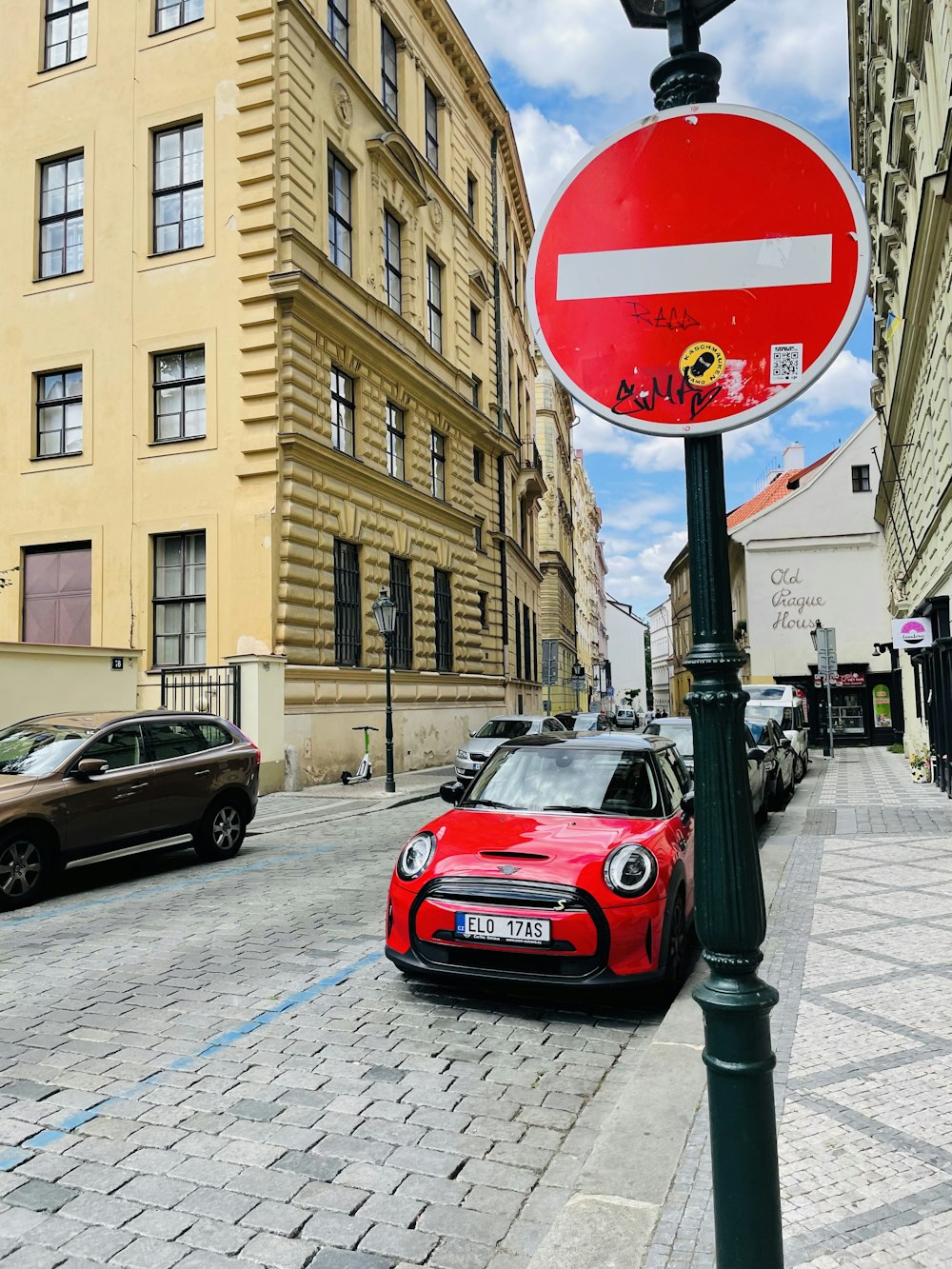 une voiture rouge garée à côté d’un panneau de signalisation