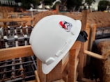 A close-up of a construction helmet resting on wooden planks.