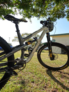Close-up of rugged mountain biking gear laid out on a wooden bench under sunlight