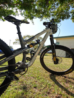 Close-up of rugged mountain biking gear laid out on a wooden bench under sunlight