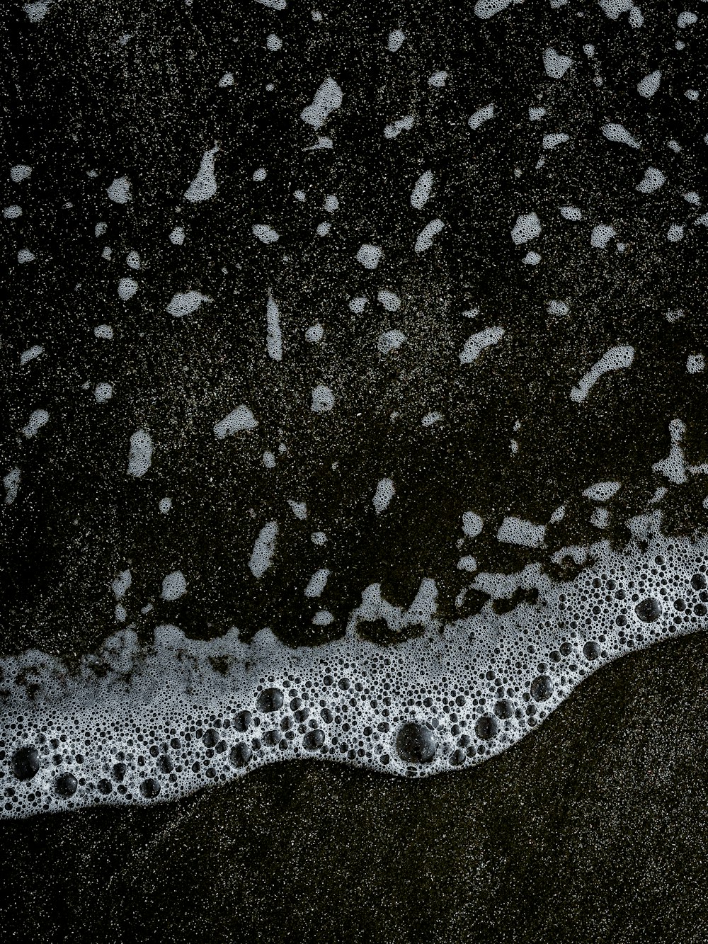 a black and white photo of water and sand