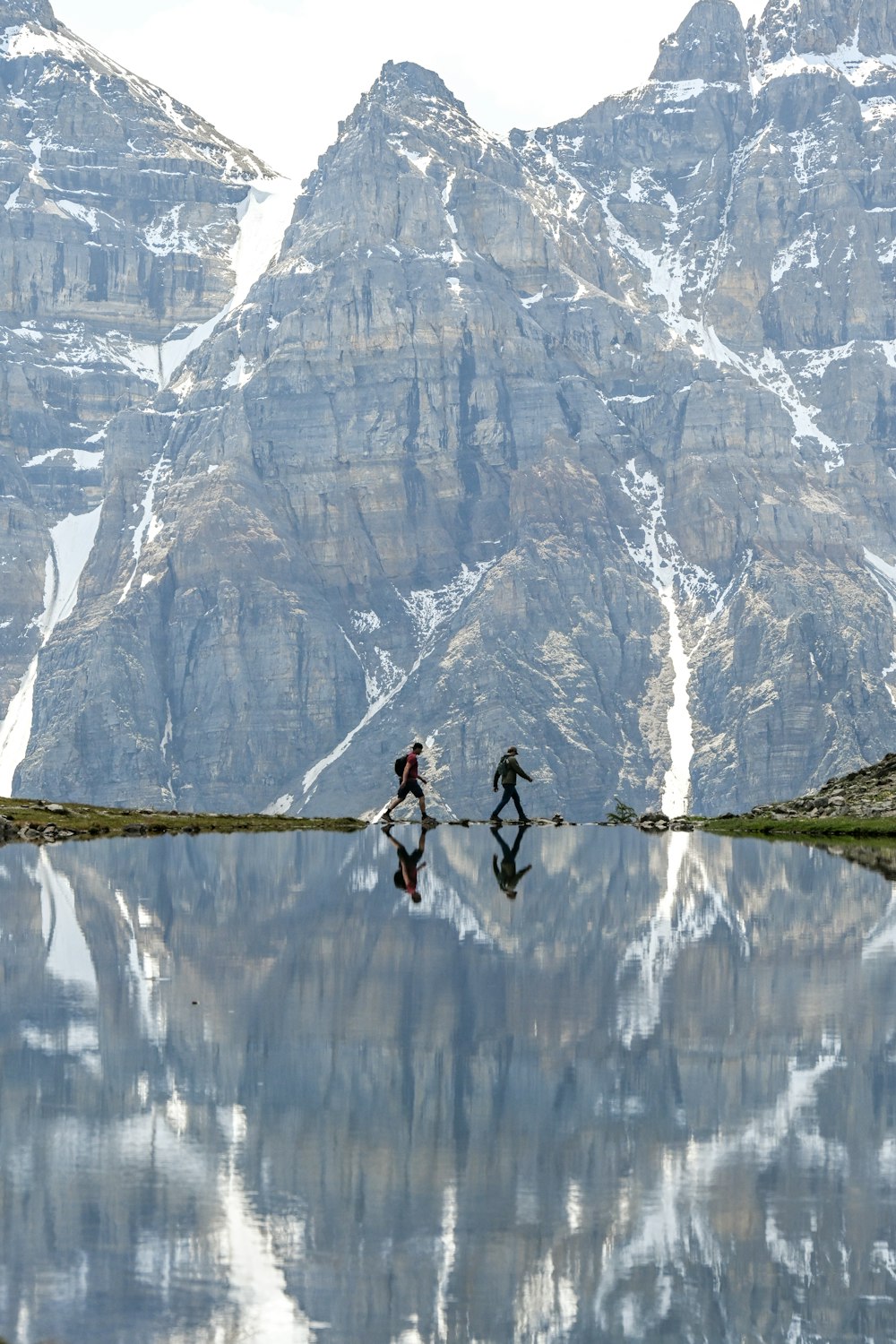a couple of people that are walking across a body of water