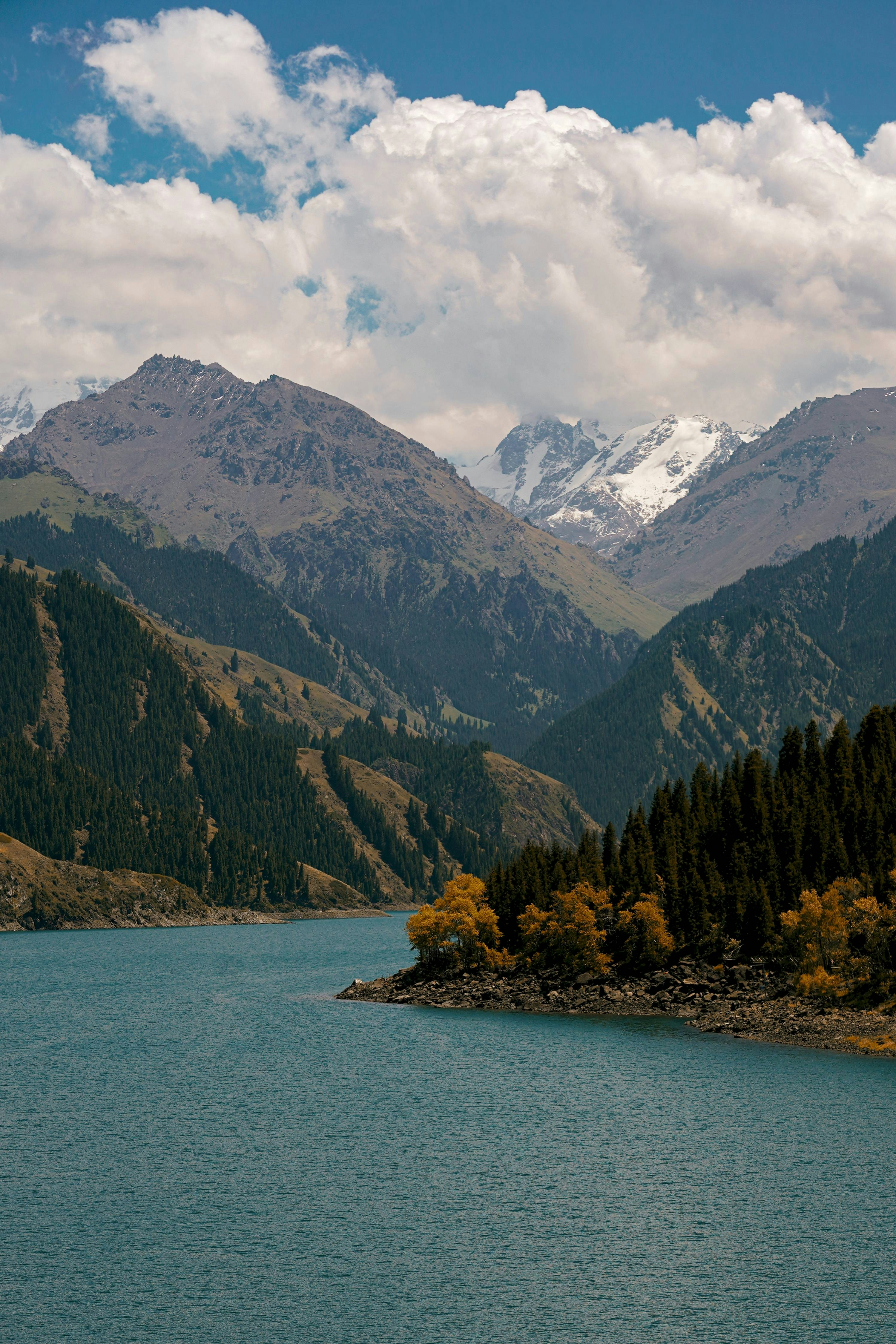 uno specchio d'acqua circondato da montagne e alberi