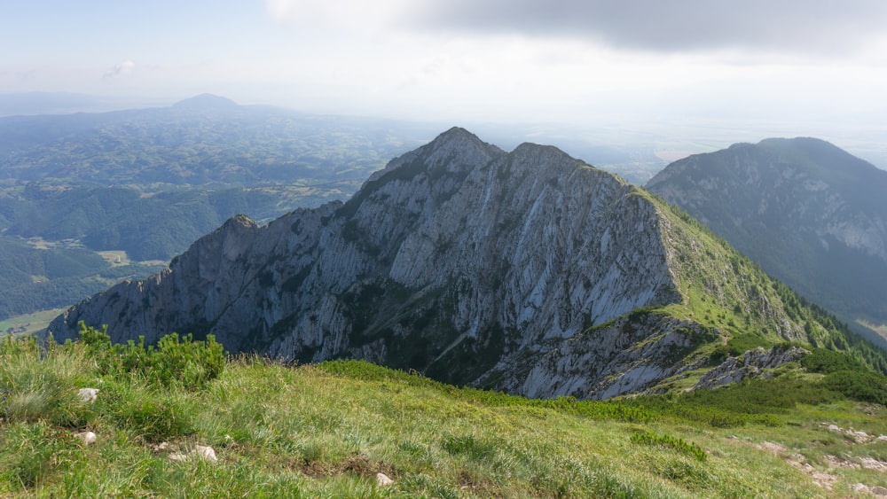 a view of a mountain range from the top of a hill