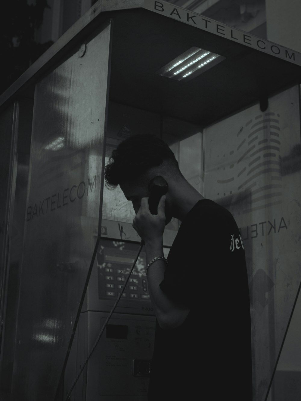a man talking on a cell phone while standing in front of a vending machine