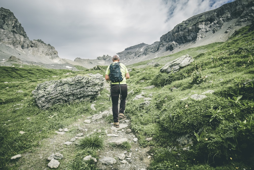 a man with a backpack walking up a trail