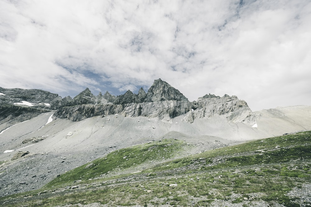 a mountain range with a few clouds in the sky