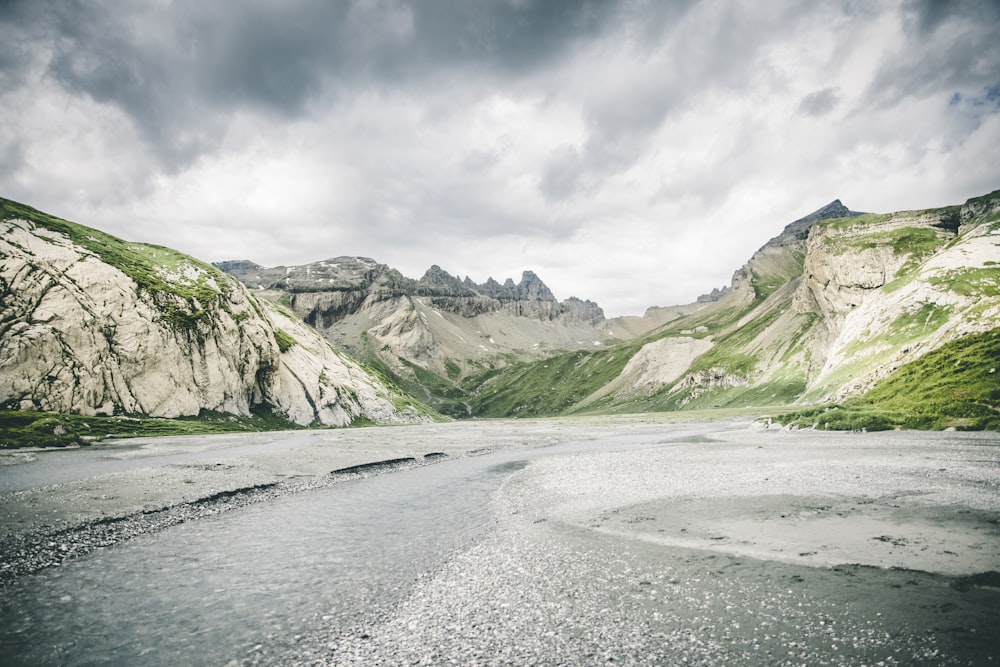 a river running through a valley surrounded by mountains