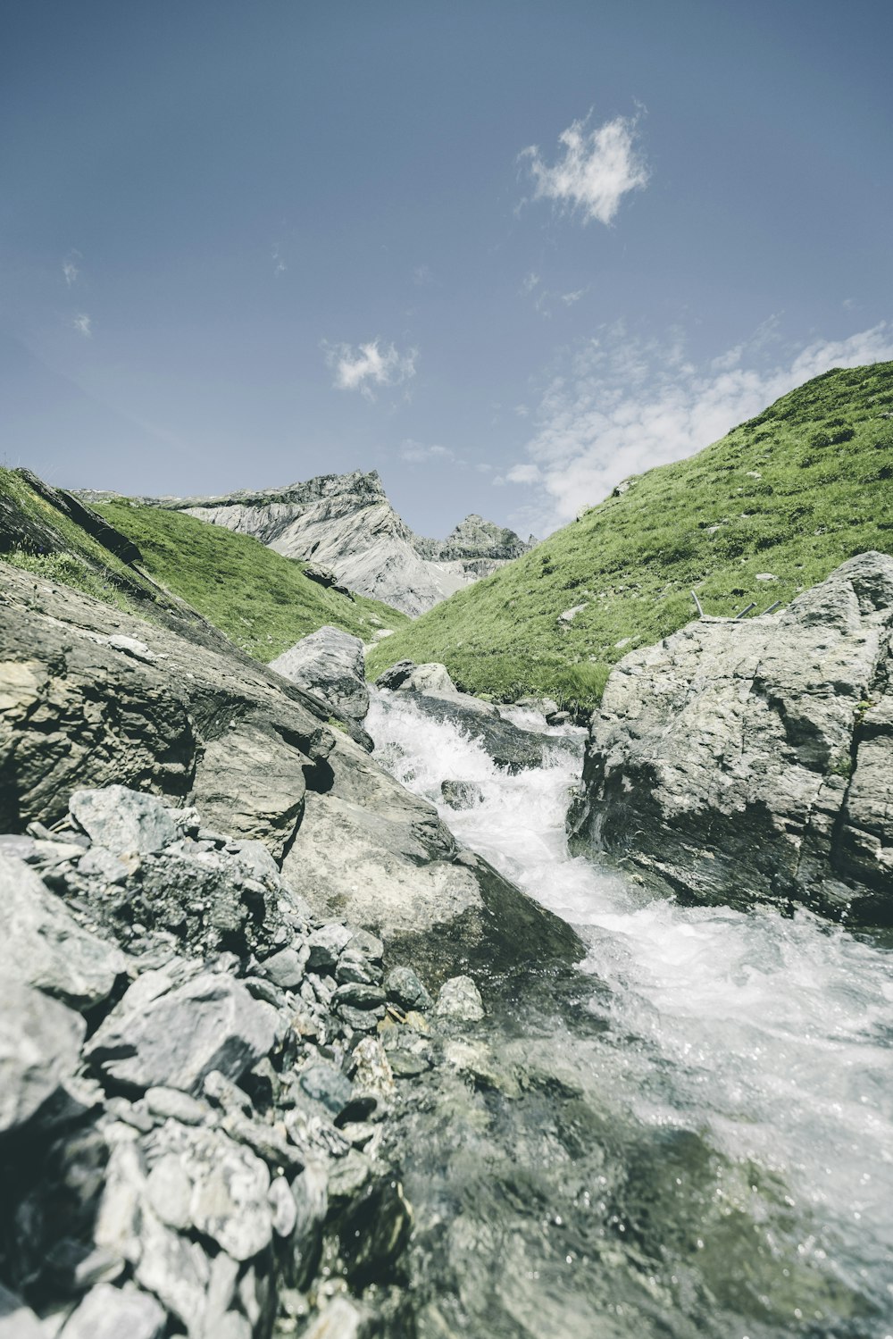 a river running through a lush green hillside