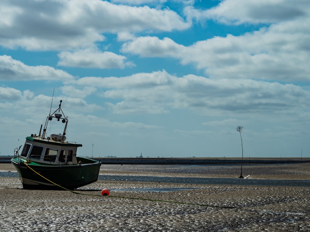 a boat sitting on top of a sandy beach