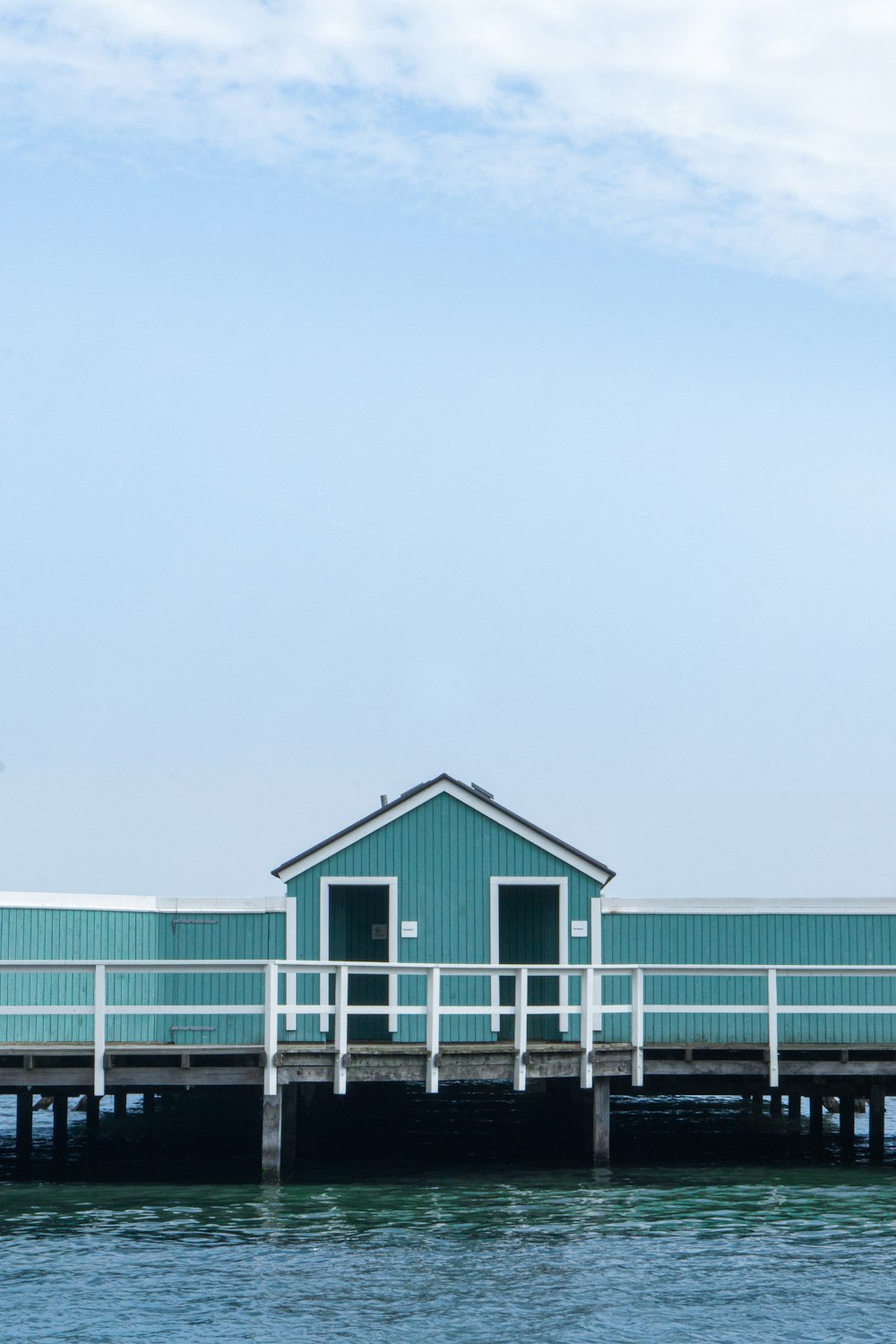 a blue house sitting on top of a pier