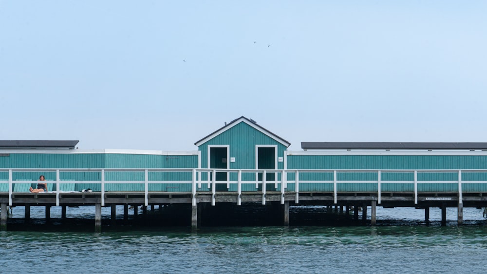 a blue building sitting on top of a pier