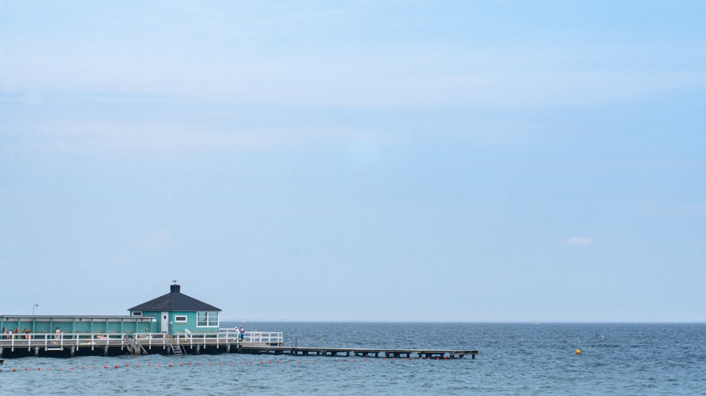a house on a pier in the middle of the ocean