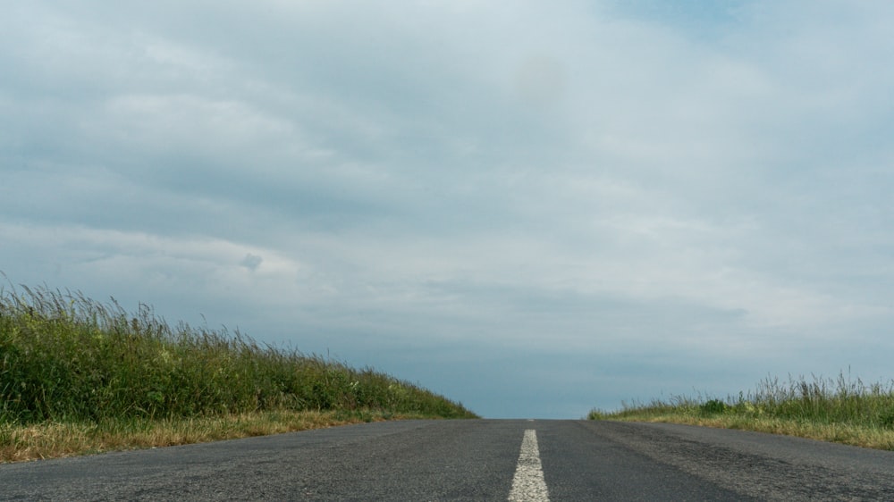 an empty road in the middle of a field