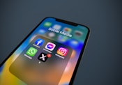 a close up of a cell phone with social media icons