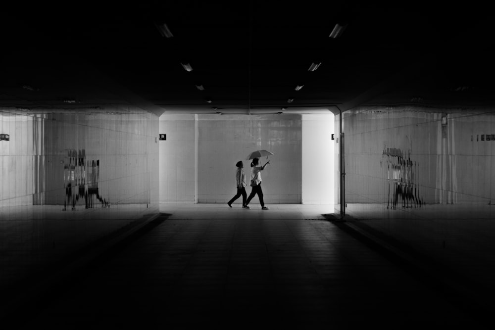 a couple of people walking through a tunnel