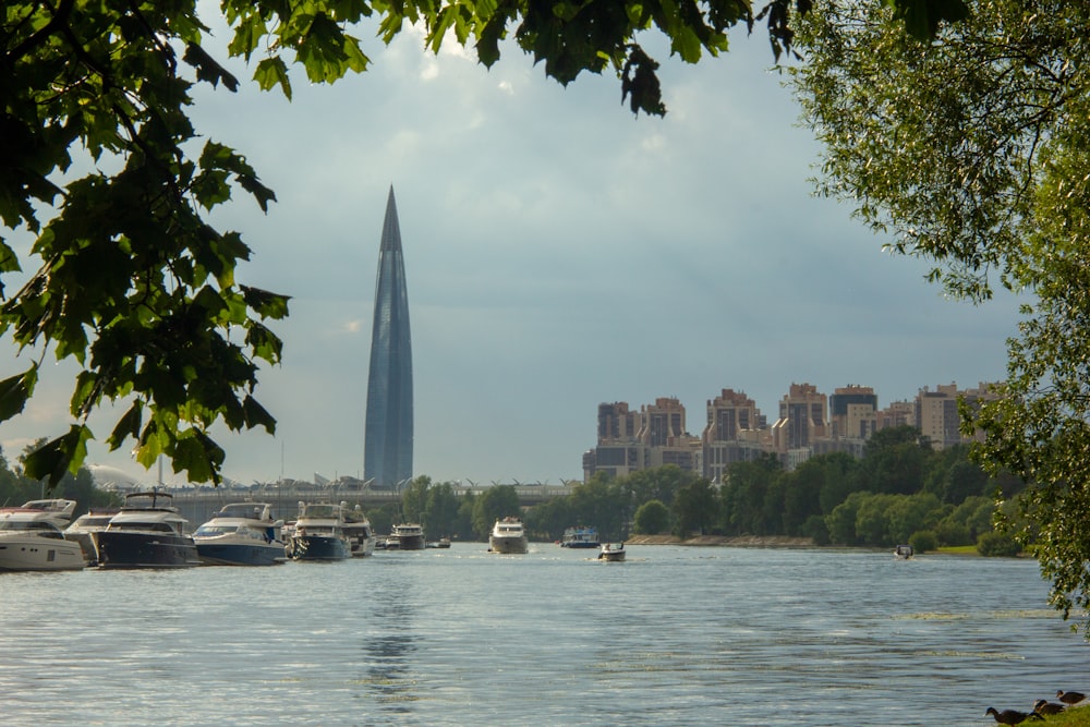 a body of water with boats and a tall building in the background